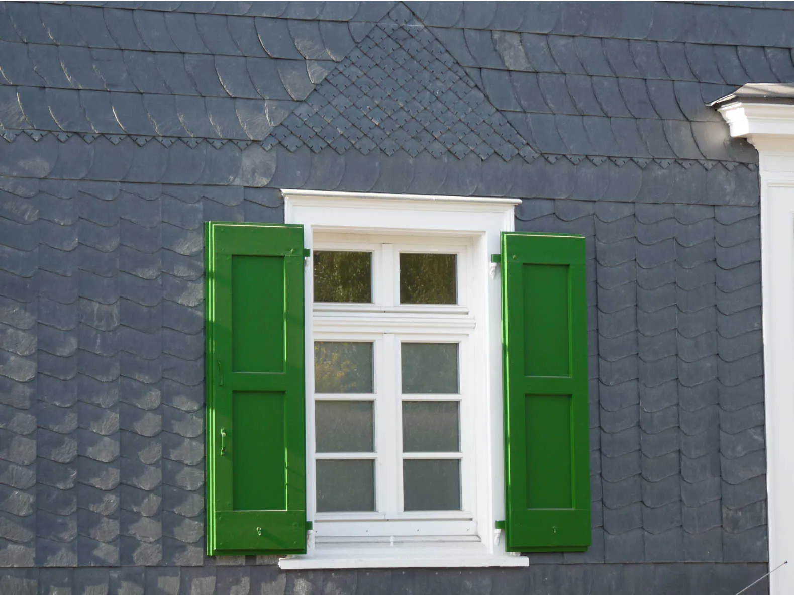 Schieferfassade mit grünen Läden